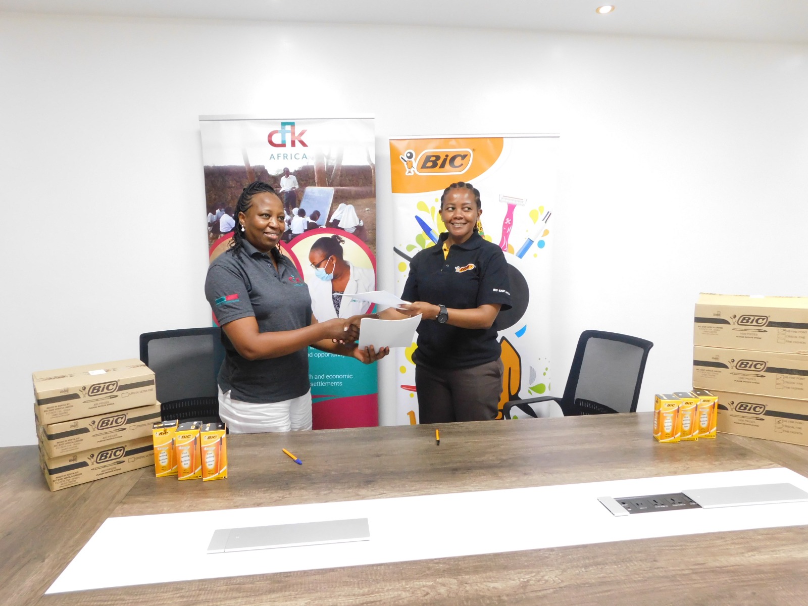 BIC East Africa Marketing Manager, Salome Ngugi, and CFK Africa Acting Executive Director, Mary Ndiba, sign and exchange contracts committing to a partnership which will reach over 150,000 Kenyan students in need. PHOTO/COURTESY
